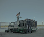 Konrad Smolenski tunes his electric tomahawk missile atop the BNNT vehicle. Image courtesy of the artist.