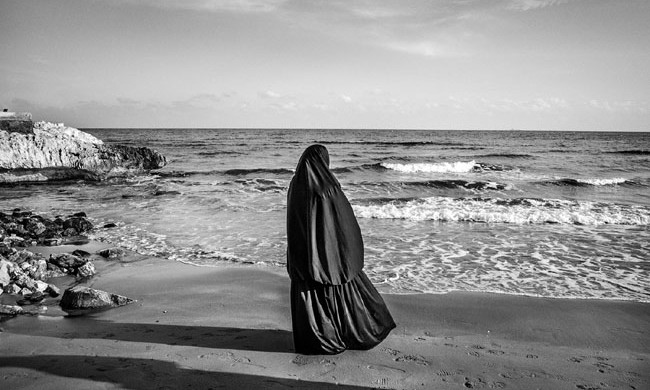 Syrian woman looks at the sea in Kizkalesi, around 60 KM west of Mersin, Turkey, while hoping to be embarked soon on a ship headed to Europe, January 29, 2015. 
As the Syrian civil war continues with no end in sight thousands of Syrian refugees arrive each year to the turkish coasts near Mersin, turning to human smuggling operations as a way to reach Europe. One of the smugglers operating out of the port of Mersin, when interviewed, reported that 6,000 $ are required, per person, to get an illegal passage to Europe on board of old freighters. According to UNHCR more than 3,000 refugees and migrants drowned in the Mediterranean in 2014 fleeing conflict-torn regions, and more than 3,700 died in the same way in 2015.