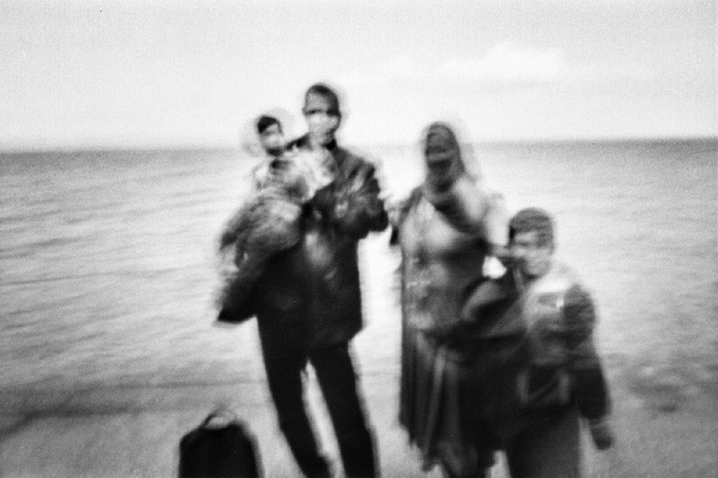 Syrian refugee family just landed after reaching, on a rubber boat from Turkey, the village of Skala Sykaminias located on the northeastern Greek island of Lesbos, on October 9, 2015. For many thousands of refugees and migrants heading to Europe from the Middle East, the long route to a new life lies through Greece and the Western Balkans with the ultimate destination in Germany and other northern EU countries. According to the UN Refugee Agency, more than 850.000 arrivals by sea were registered in Greece in 2015.