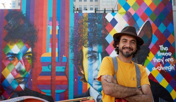 International mural artist, Eduardo Kobra, stands in front of his mural of Bob Dylan in downtown Minneapolis.